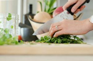a lady chopping herbs/vegetables
